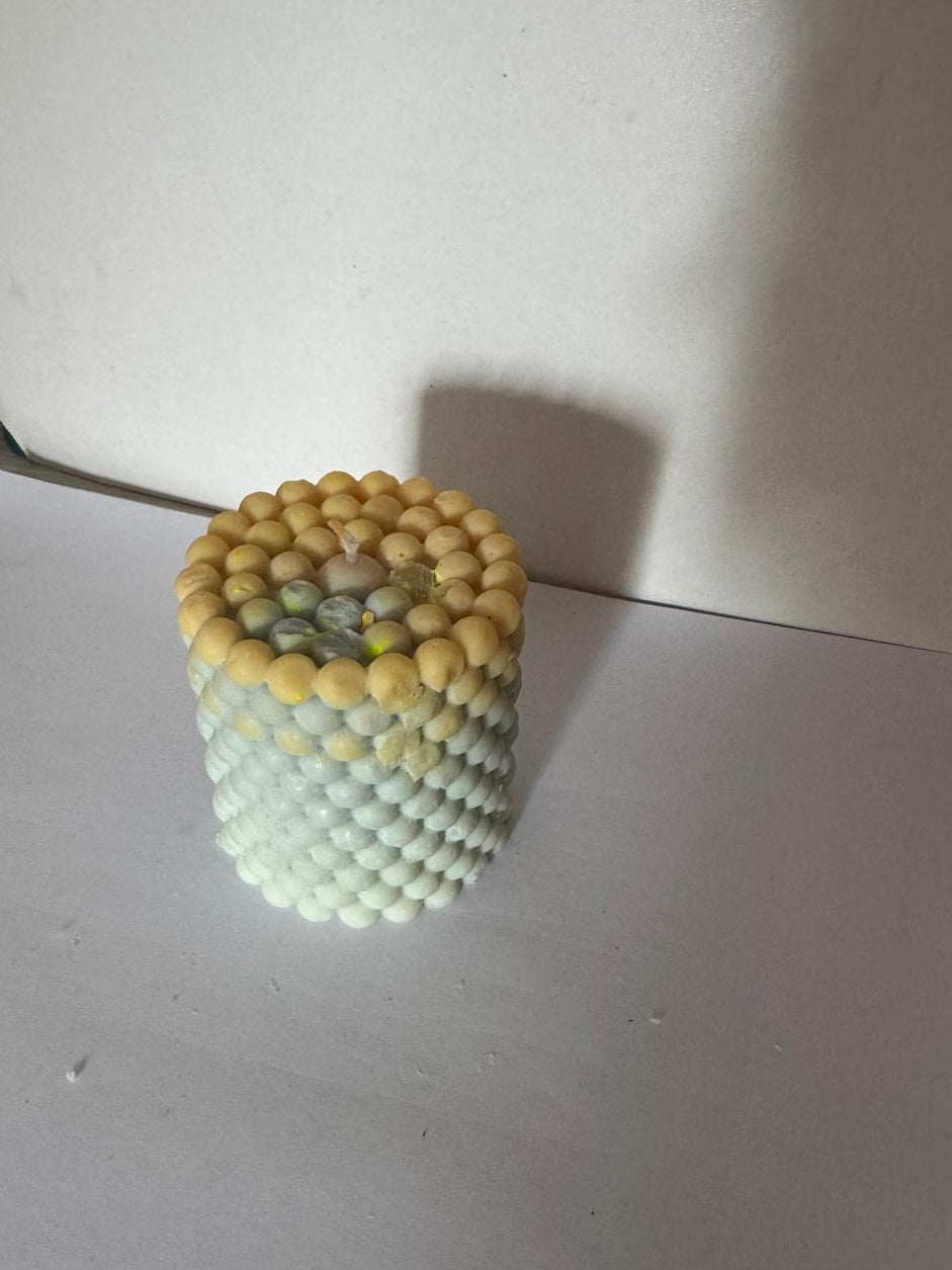 Decorative vase made of small beads on a plain surface